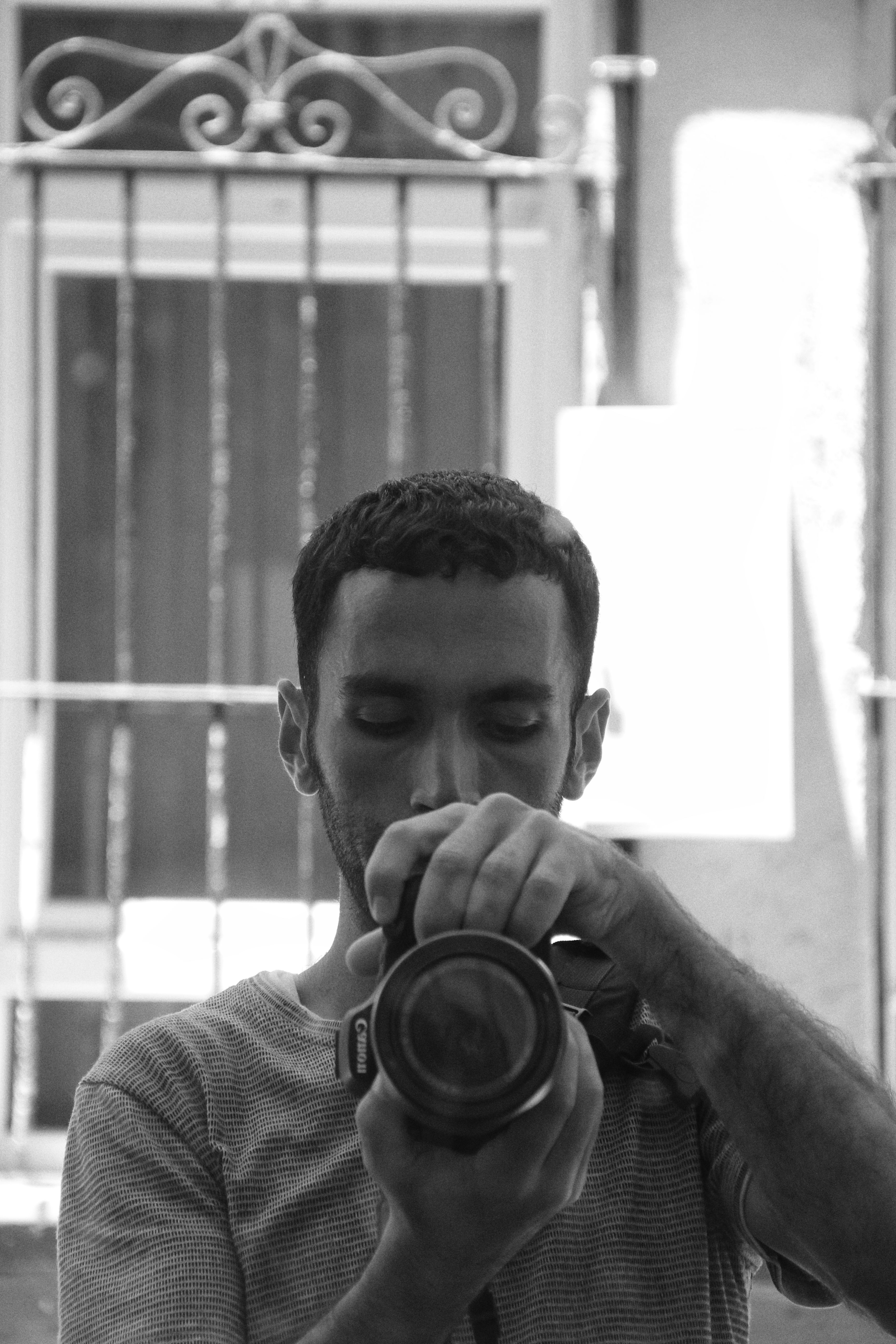 A man taking a self-portrait in a mirror showing urban reflections in Fatih, Istanbul.
