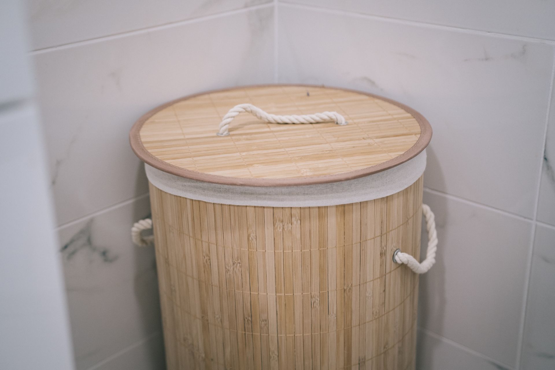 A stylish bamboo laundry basket adds a natural touch to a modern bathroom design.