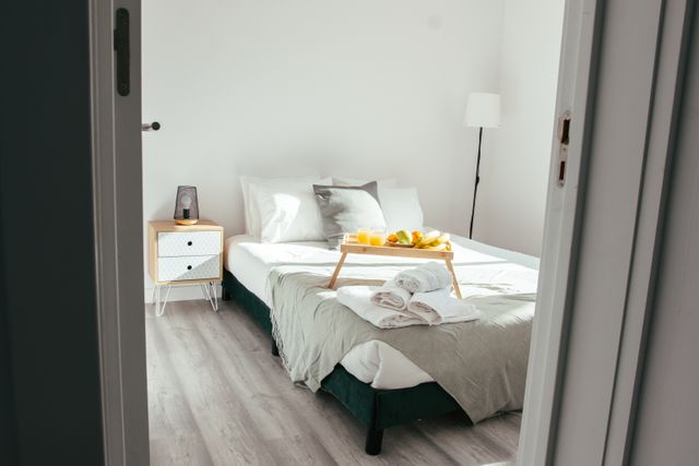 Made bed with folded towels and a breakfast tray — photo by Jaycee300s on Pexels