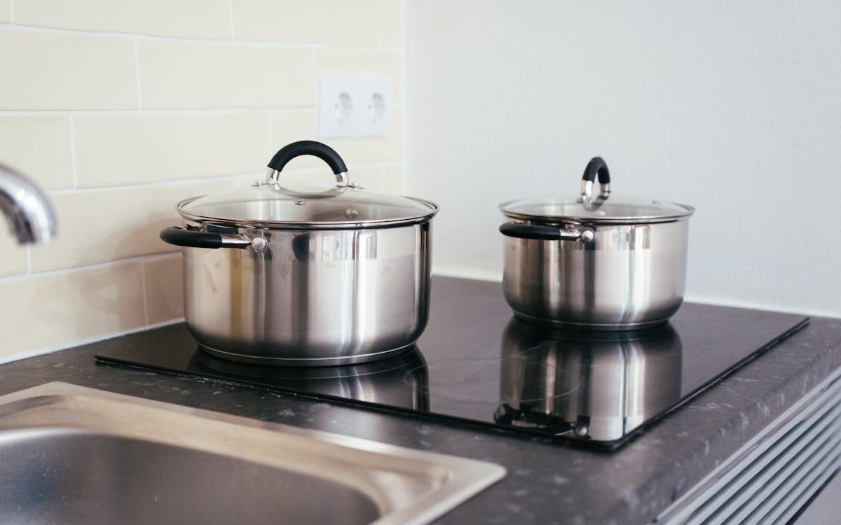 Contemporary kitchen setup with stainless steel pots on an induction stove.
