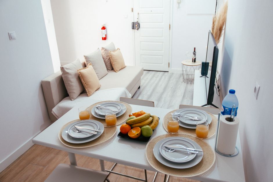 Modern apartment dining area with a fresh fruit centerpiece and neatly set table.