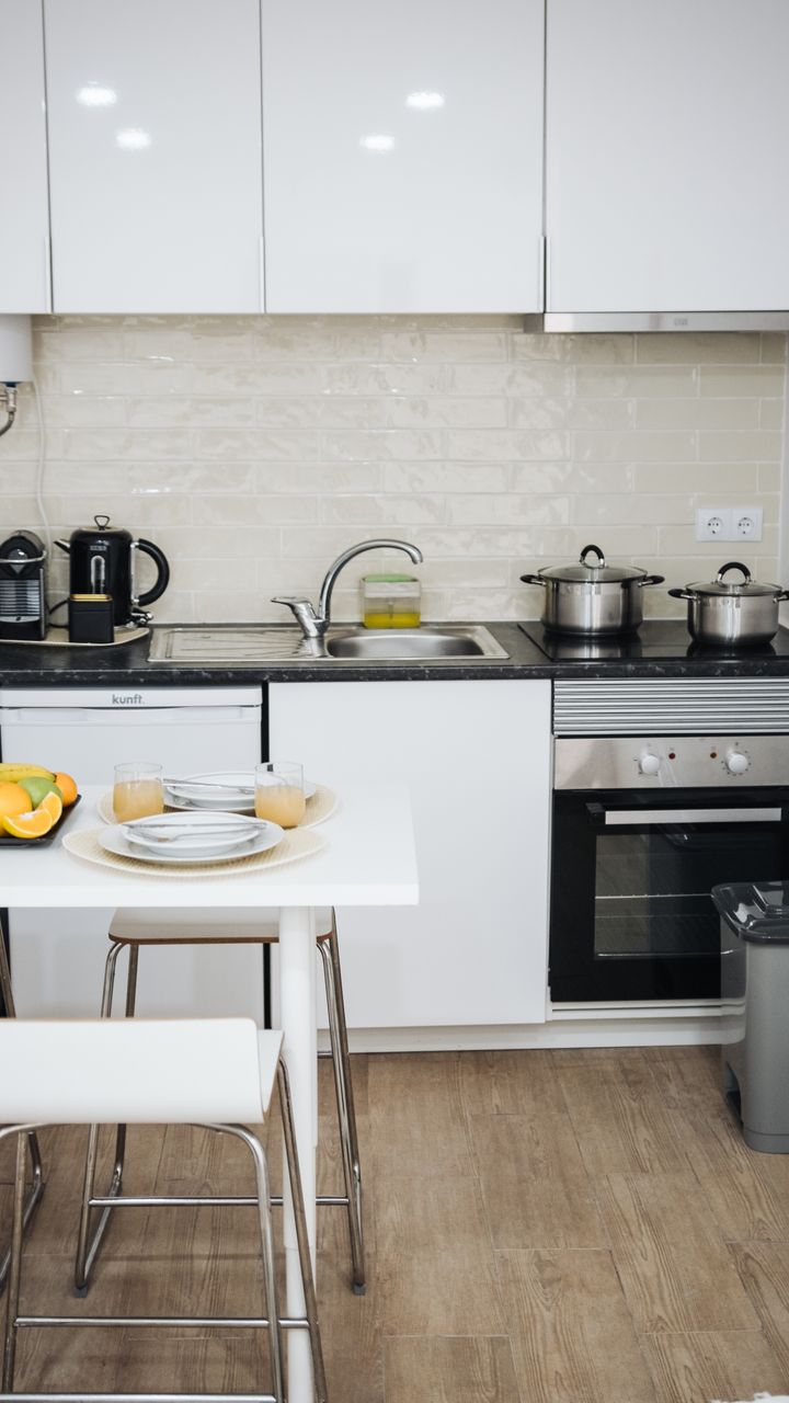 small stainless steel lidded trash bin tucked next to a kitchen coffee bar