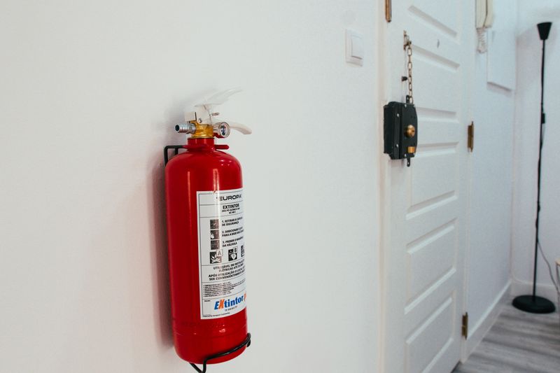 Fire extinguisher mounted on a wall in an apartment hallway