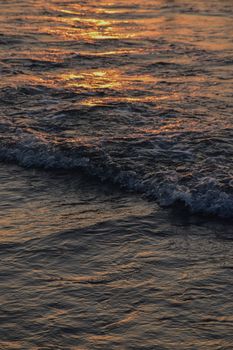 Captivating sunset reflection on ocean waves at twilight.