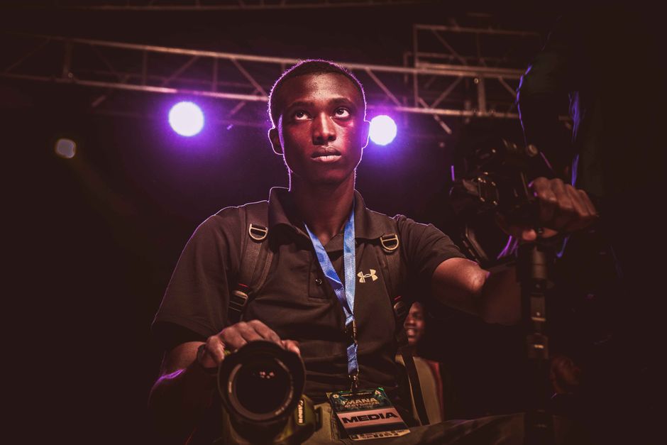 A professional photographer with media badge captures a live concert.