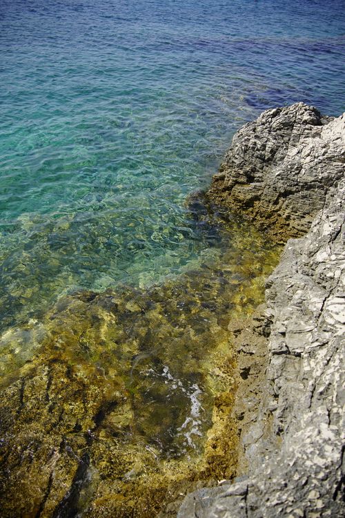 Free Vibrant rocky shoreline with clear blue waters in Pola, Istria. Stock Photo
