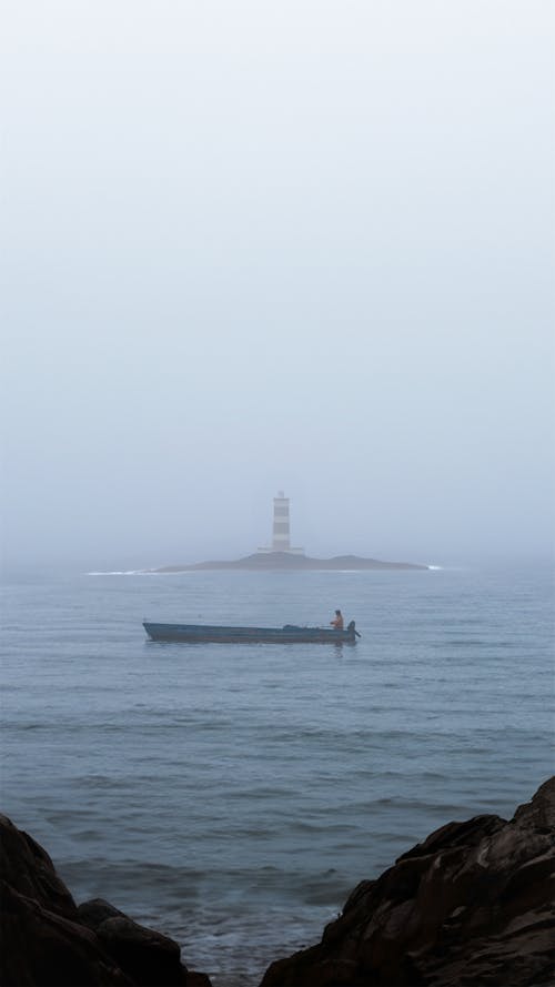 Fishing Motorboat Sailing by Islet with Lighthouse