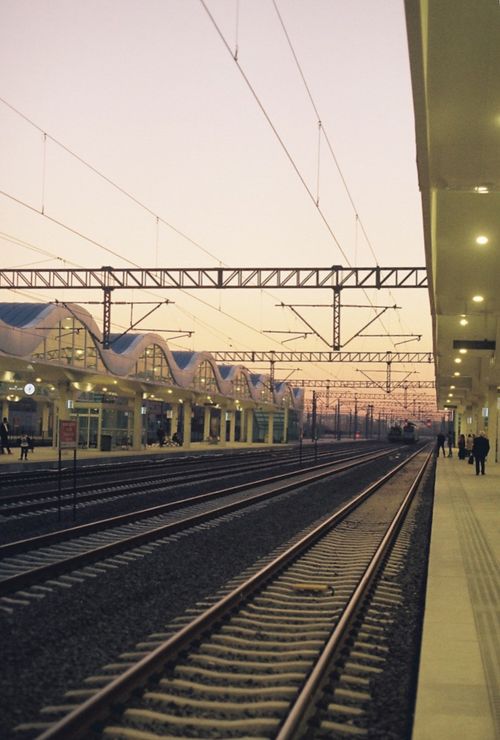 Free A tranquil evening scene of a modern railway station at sunset, capturing a peaceful moment in transportation. Stock Photo