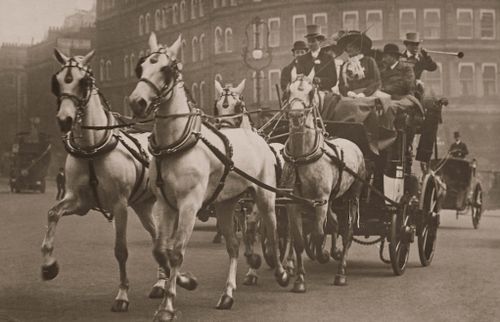 Free Elegant vintage photo of a horse-drawn carriage with passengers in a historical city scene. Stock Photo