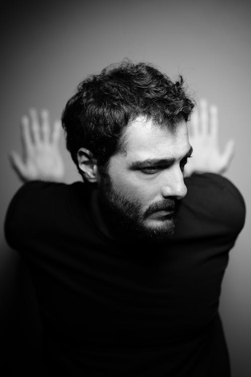 Black and White Portrait of a Bearded Man Sitting on a Floor