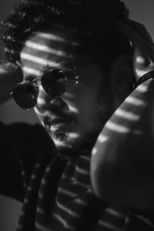 Free Black and white portrait of a man in sunglasses with dramatic shadows and stripes. Stock Photo