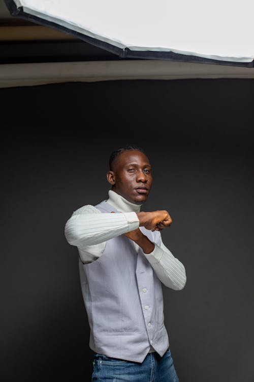 Man Posing in White Turtleneck Sweater and Gray Vest