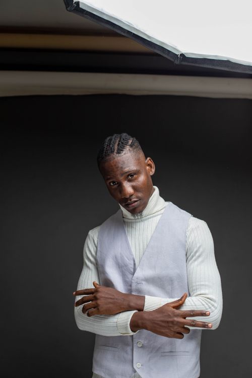 Free Studio portrait of an adult man in a turtleneck sweater with crossed arms against a dark background. Stock Photo
