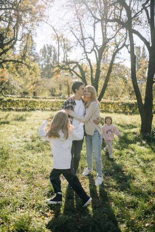 Free Family having fun outdoors with children in a sunny park. Joyful moments captured. Stock Photo