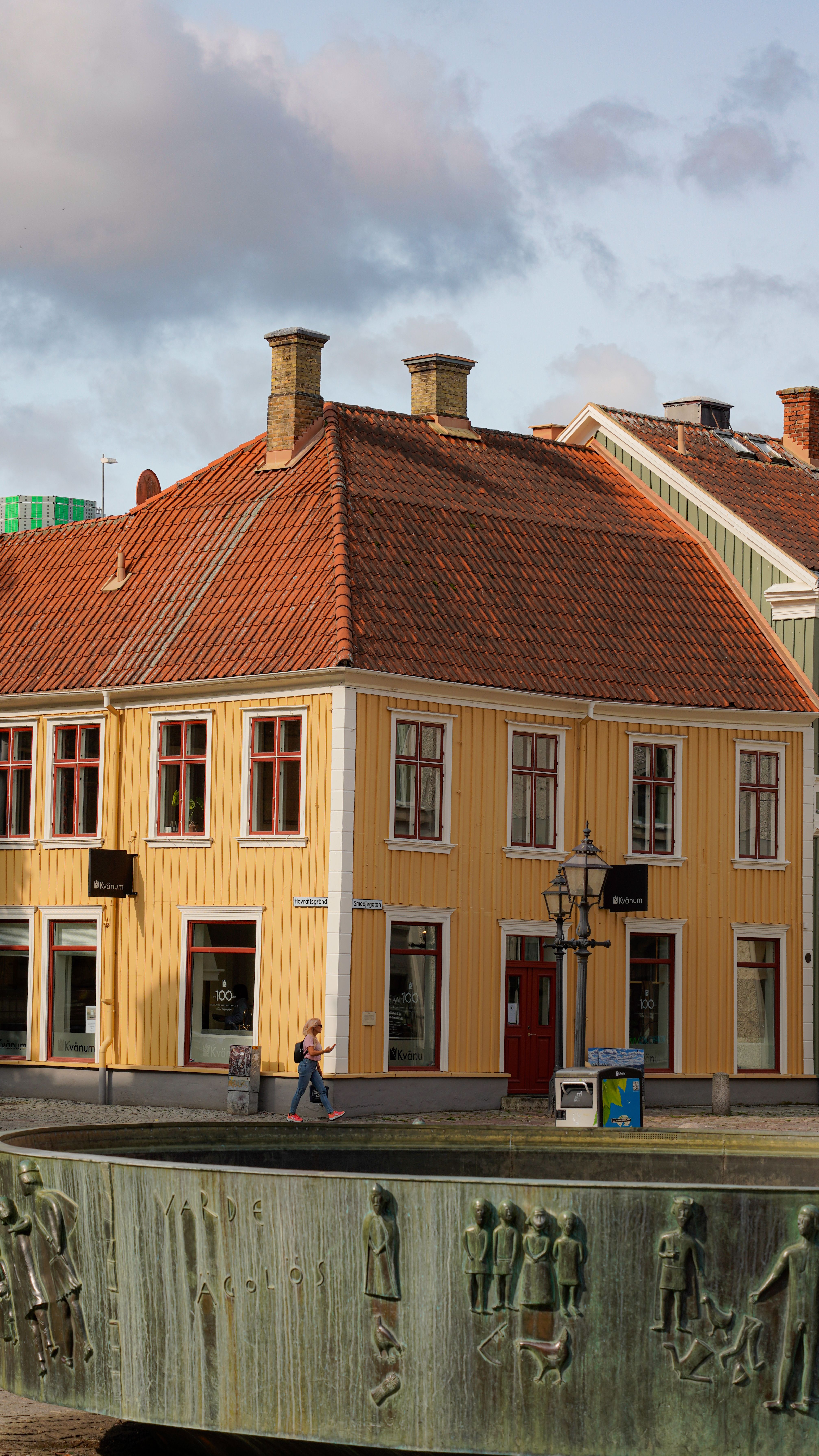 A beautiful view of a historical street corner with distinctive architecture and a fountain.