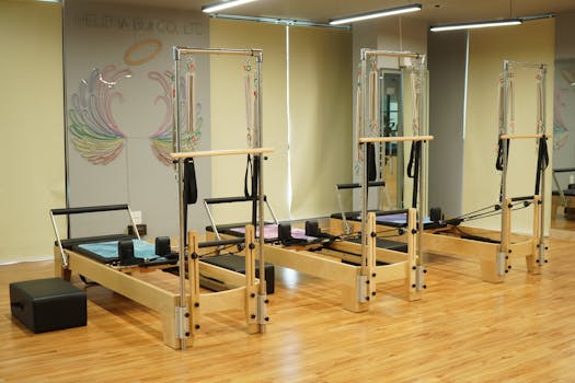 Spacious Pilates studio featuring wooden reformers and minimalistic decor.