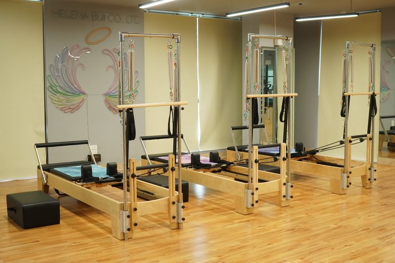 Spacious Pilates studio featuring wooden reformers and minimalistic decor