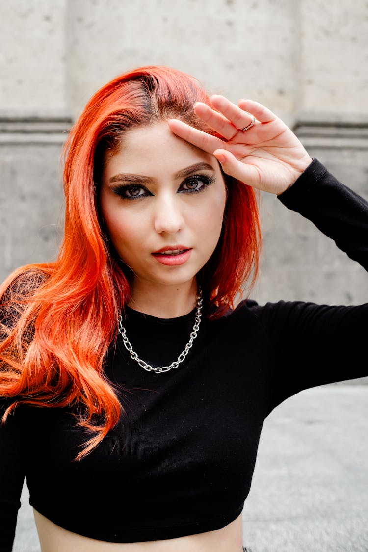 Redhead Woman In Black Long Sleeve Crop Top Fixing Hair