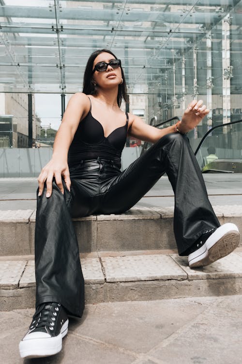 Model in Leather Pants and Black Sleeveless Bodysuit Sitting on the Subway Entrance Steps