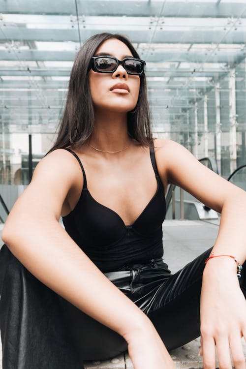 Young Brunette in Sunglasses Sitting on Ground