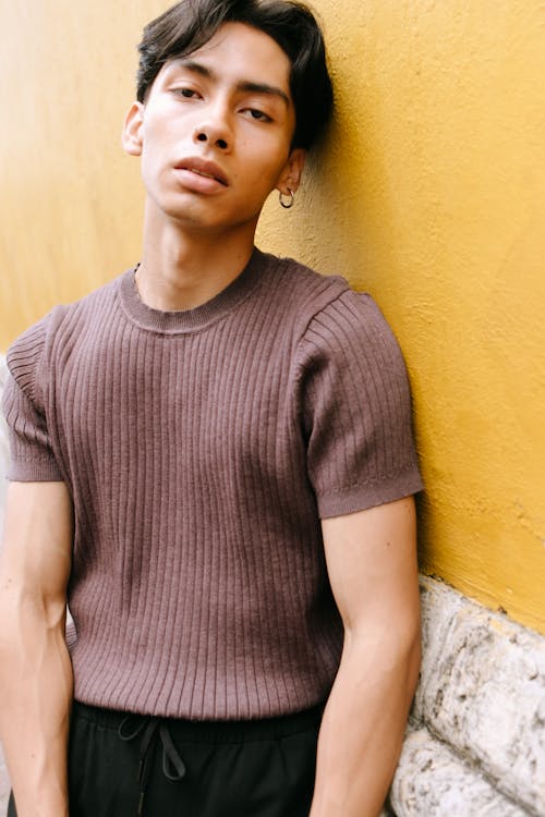 Man with Earring Leaning against Yellow Wall