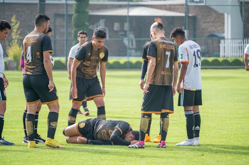 Player Lies with Pain on Football Pitch