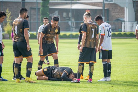 Soccer players gather around injured teammate during a match in Texcoco, Mexico.