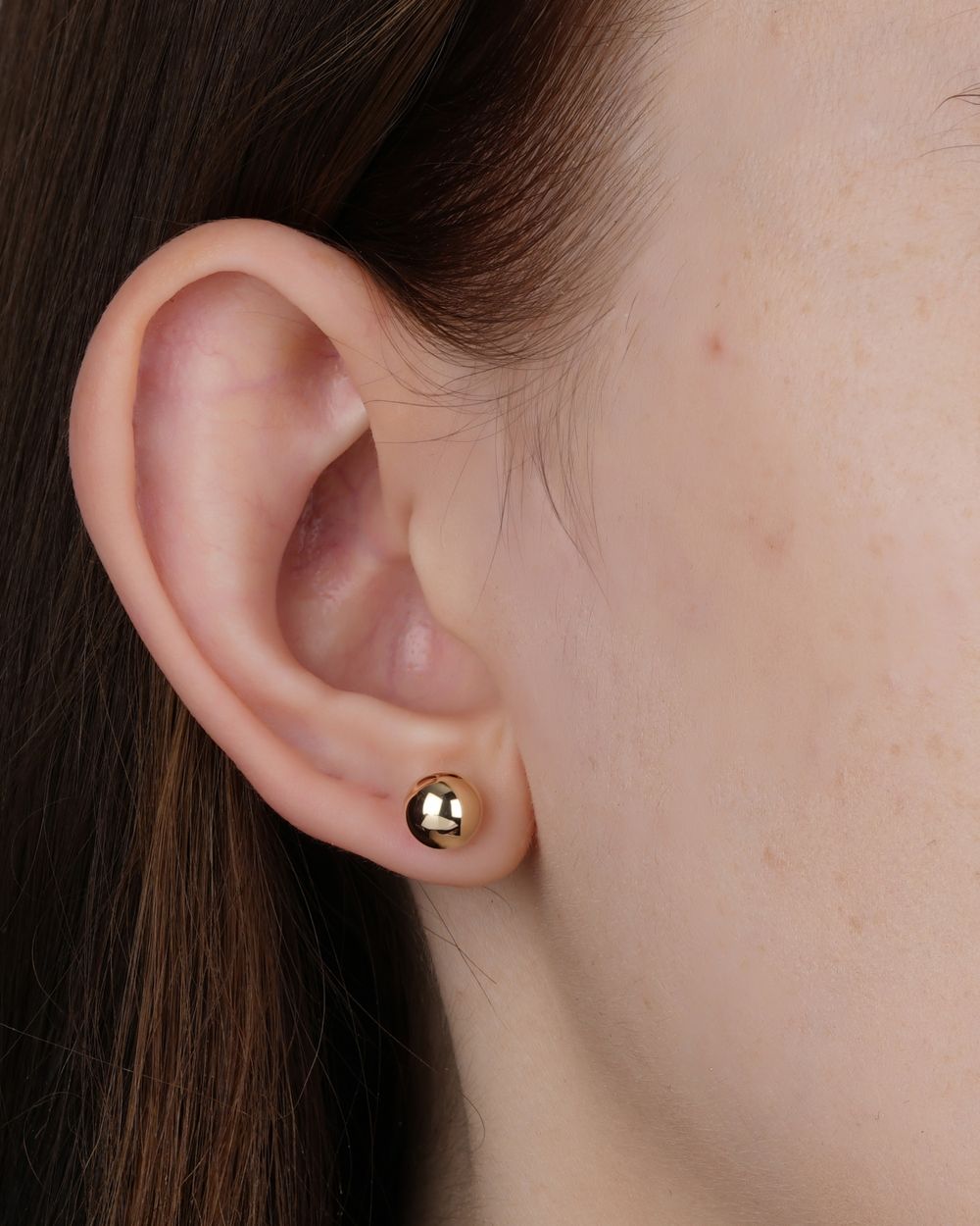 Small gold stud worn on ear
