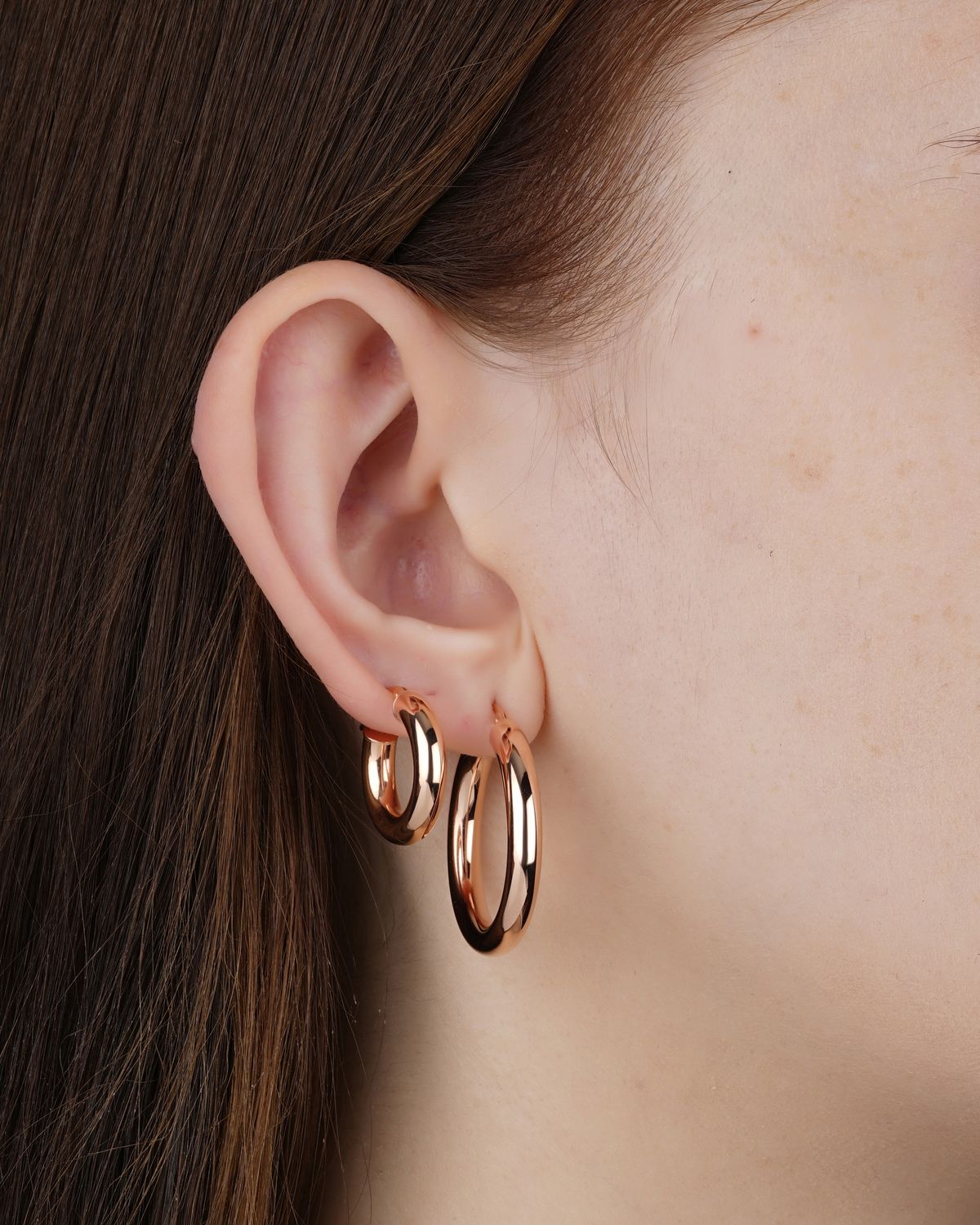 Close-up of gold hoop earrings worn on an ear