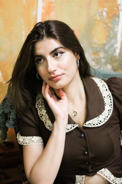 Young Woman in a Shirt Sitting and Looking Away 