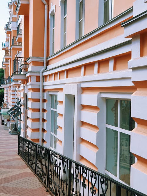 Facade of a Renovated Tenement House and a Sidewalk in City 