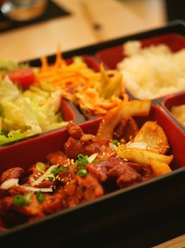 Close-up of a delicious, vibrant bento box with various fresh ingredients.