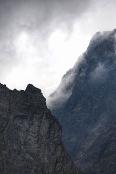 Captivating view of rugged mountain peaks shrouded in misty clouds in Wysokie Tatry, Slovakia.