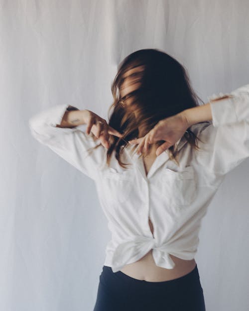 Standing Woman in Tied Crop Top Tossing Hair