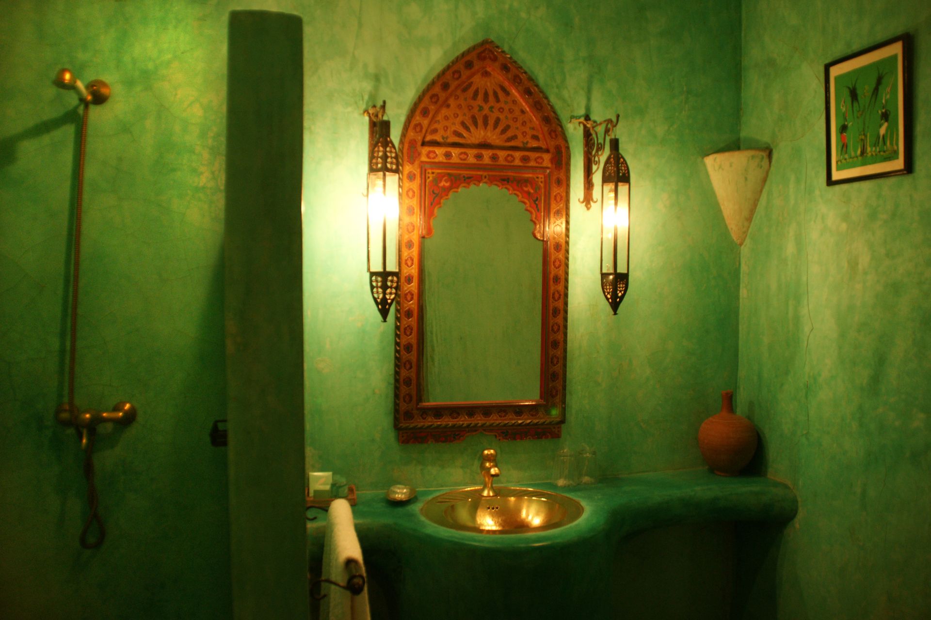 Luxurious Moroccan bathroom with green decor and intricate wooden mirror, exuding exotic charm.