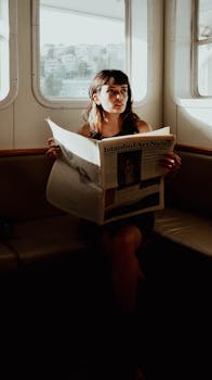 Woman reading a newspaper on a ferry in İstanbul, creating a peaceful travel moment.