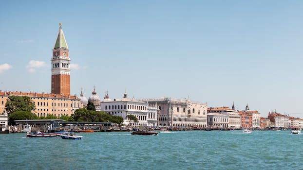 Beautiful view of Venice's St. Mark's Campanile and waterfront buildings on a sunny day.