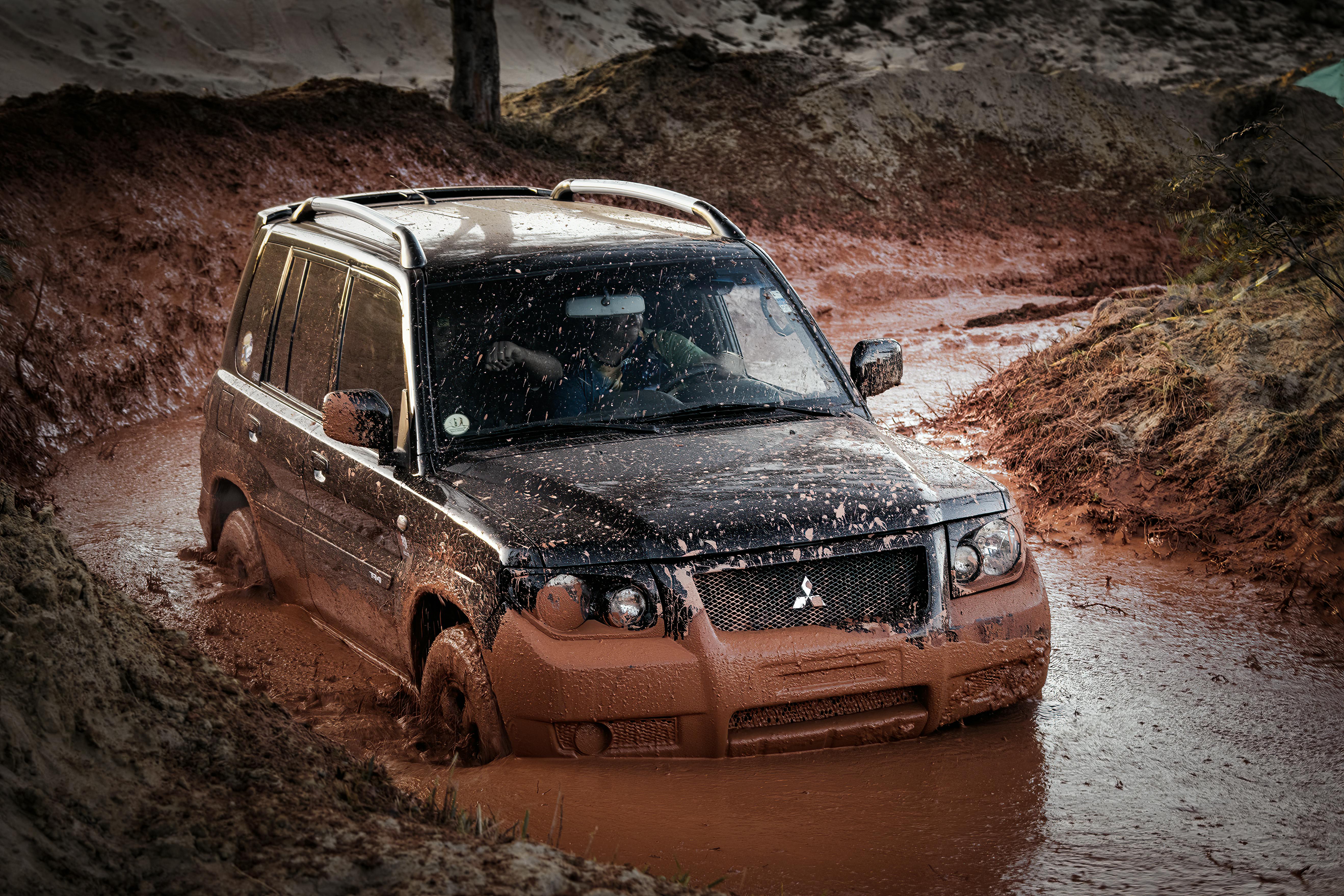 A Mitsubishi SUV challenging a muddy off-road track, showcasing adventure and rugged performance.