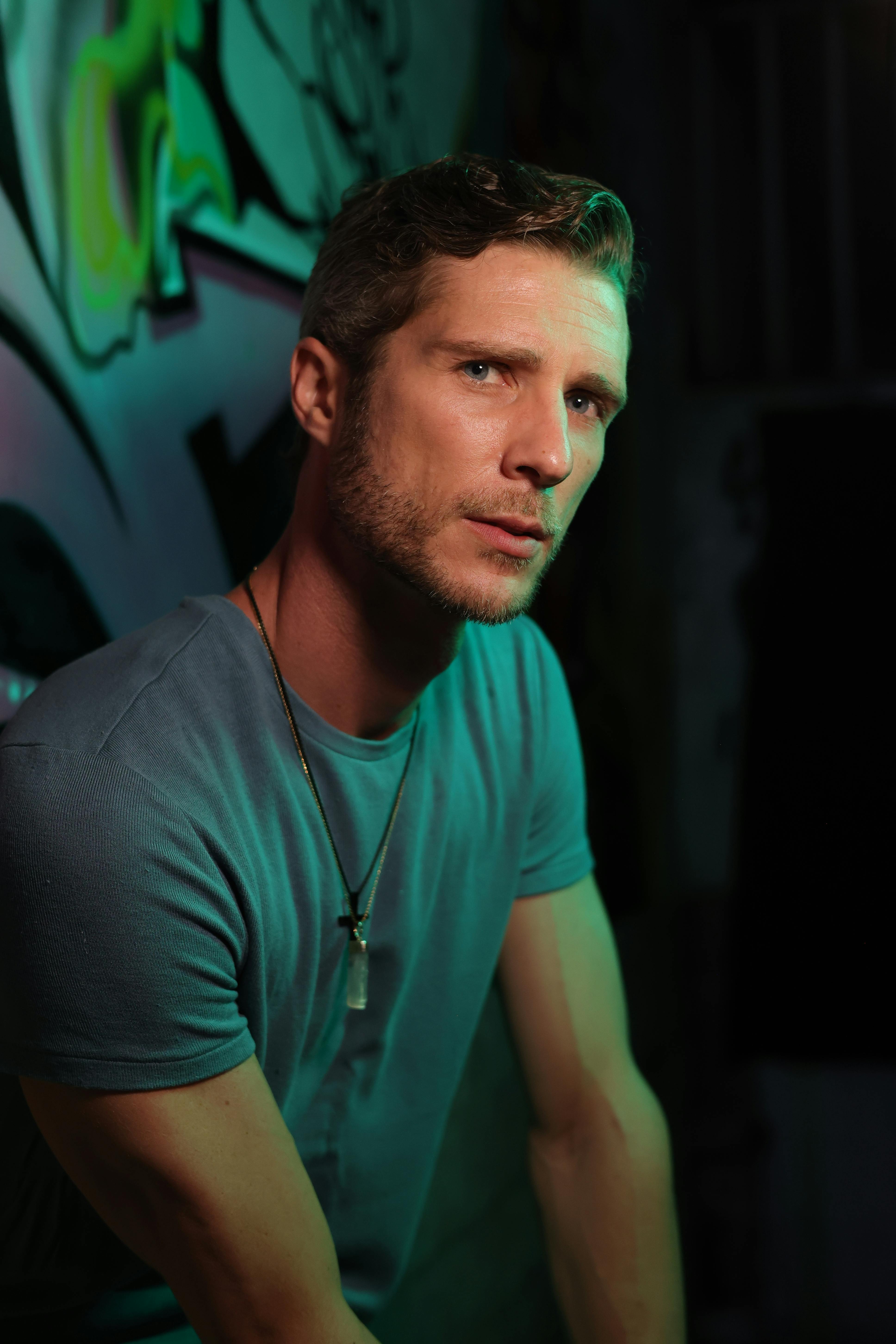 Creative portrait of a man posing against a graffiti wall, exuding a stylish urban vibe.