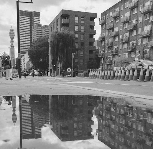 Residential Buildings Reflecting in Puddle on Sidewalk