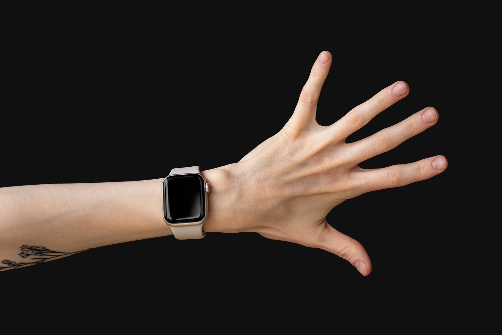 Person gently supporting a sore wrist and hand near a bright window