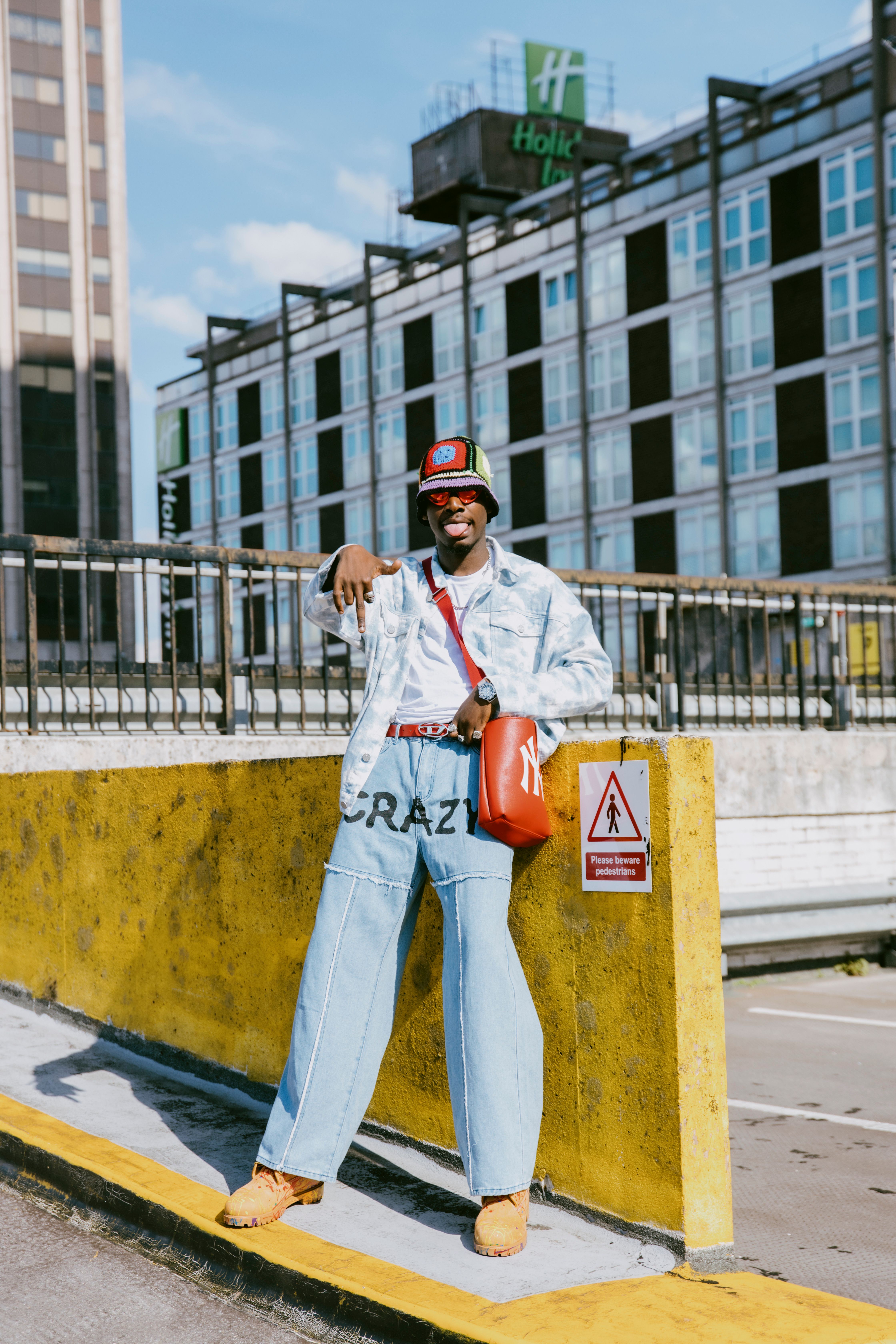 Man Posing by a Yellow Wall · Free Stock Photo