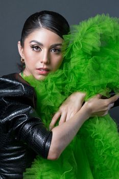 Stunning portrait of a woman embracing vibrant green fashion in a studio setting.