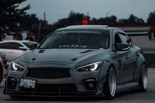 Free Gray sports car with modifications and decals captured during drifting in a parking lot. Stock Photo