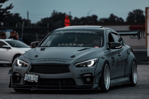 Free A sleek grey sports car with custom decals and a hood scoop parked outdoors. Stock Photo