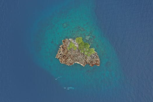 Stunning aerial view of a solitary tropical island in clear blue waters of Indonesia.