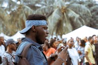 一名年轻人在热闹的街头节日中用手机抓拍瞬间