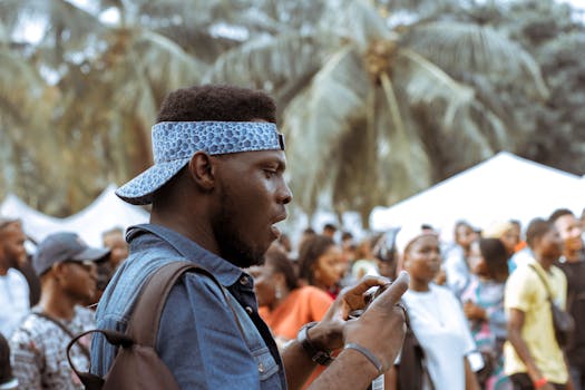 一名年轻人在热闹的街头节日中用手机抓拍瞬间