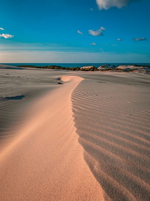 Free Explore the serene beauty of Łeba's sandy dunes meeting the azure Baltic Sea under a clear sky. Stock Photo