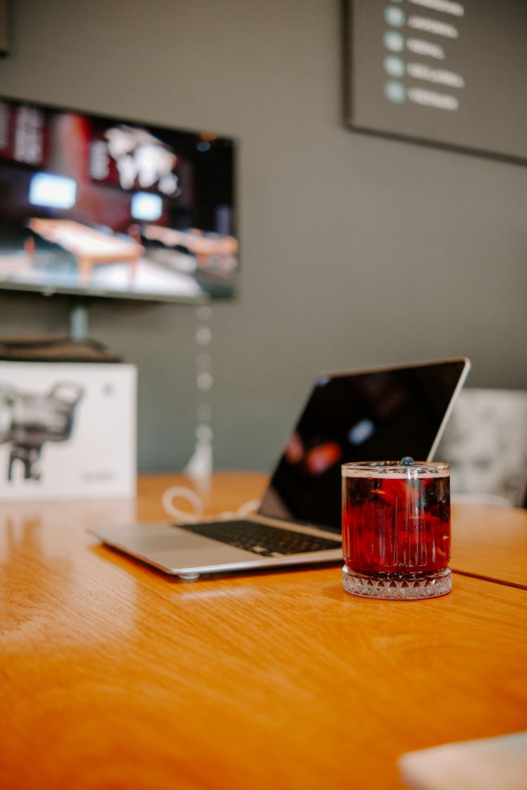 A Laptop And A Glass Of Juice On The Table 